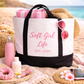 Beach bag with 'Soft Girl Life' branding on a sandy background